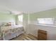 Comfortable bedroom featuring a ceiling fan, wood flooring, and natural light from the window at 2601 Gulf N Dr # 733, Bradenton Beach, FL 34217
