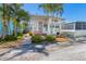 Charming coastal home featuring a coral door, lush landscaping, and a cozy, inviting entryway at 2601 Gulf N Dr # 733, Bradenton Beach, FL 34217