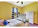 Bright bedroom featuring yellow walls, white furnishings, and a window at 2729 Harvest Dr, Sarasota, FL 34240