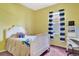 Bright bedroom with yellow walls, white furniture, and a window with blue curtains at 2729 Harvest Dr, Sarasota, FL 34240