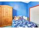 Blue bedroom with wood armoire, patterned bedding, and bright natural light at 2729 Harvest Dr, Sarasota, FL 34240
