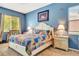Comfortable bedroom featuring a colorful quilt on the bed, blue walls, and a white bedside table at 2729 Harvest Dr, Sarasota, FL 34240