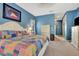 Colorful bedroom with blue walls, a white dresser, and a patterned quilt on the bed at 2729 Harvest Dr, Sarasota, FL 34240