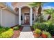 The red double door is framed by white columns and lush landscaping at 2729 Harvest Dr, Sarasota, FL 34240