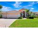 Charming home featuring a Spanish tile roof, three-car garage, and lush landscaping at 2729 Harvest Dr, Sarasota, FL 34240