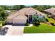 Beautiful aerial view of a home featuring a Spanish tile roof, three-car garage, and lush landscaping at 2729 Harvest Dr, Sarasota, FL 34240