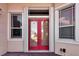 A close up view of the glass insert red double front door, framed by sidelight windows at 2729 Harvest Dr, Sarasota, FL 34240