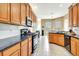Well-lit kitchen with modern black appliances, wood cabinets, tile flooring, and black countertops at 2729 Harvest Dr, Sarasota, FL 34240