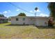 View of the home's backyard and back exterior, showing a grassy area and neighboring houses at 2739 Palmadelia Ave, Sarasota, FL 34234