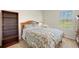 Bedroom with a comfortable bed, bedside table with lamp, and an open wooden bookshelf at 27519 Pasto Dr, Punta Gorda, FL 33983