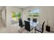 Bright dining area features glass table with black chairs and sliding doors to the patio at 27519 Pasto Dr, Punta Gorda, FL 33983