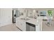 Bright kitchen boasts stainless appliances, white cabinetry, and island with breakfast bar open to the living space at 27519 Pasto Dr, Punta Gorda, FL 33983