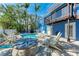 Backyard poolside patio with chairs and stone table next to the bright blue building at 301 Highland Ave # 3, Bradenton Beach, FL 34217