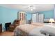 Bedroom with light blue walls, two beds with floral quilts, and a display cabinet at 307 White Oak Way, Sarasota, FL 34237