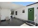 Covered carport and entrance with green door and white vinyl siding, offering protection from the elements at 307 White Oak Way, Sarasota, FL 34237