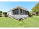 Relaxing screened in porch with a well manicured lawn and beautiful landscaping around the home at 307 White Oak Way, Sarasota, FL 34237