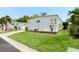 Well-maintained mobile home featuring verdant lawn, landscaping, and ample parking for a comfortable lifestyle at 307 White Oak Way, Sarasota, FL 34237