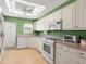 Well-lit kitchen with white cabinetry, modern appliances, and a view to the backyard at 307 White Oak Way, Sarasota, FL 34237