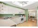 Bright kitchen with white appliances, green walls, and skylight, adjoining the dining area at 307 White Oak Way, Sarasota, FL 34237