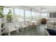 Sunroom with tile flooring, light-colored furniture, and many windows overlooking the water at 307 White Oak Way, Sarasota, FL 34237
