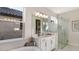 Bright bathroom featuring double vanity, a modern glass enclosed shower, and a soaking tub at 3221 Vicenza Ct, Bradenton, FL 34211