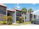 Condominium building showcases terracotta roofing, exterior balconies, lush landscaping, and convenient parking at 3269 Beneva Rd # 103, Sarasota, FL 34232