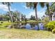 Scenic pond surrounded by lush greenery and palm trees, creating a serene and picturesque setting at 3269 Beneva Rd # 103, Sarasota, FL 34232
