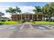 Exterior view of the community clubhouse with a brick facade, columns, and handicap parking spaces at 3308 Oakwood S Blvd, Sarasota, FL 34237