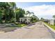 View of the gated community entrance with palm trees, landscaping, and an American flag at 3308 Oakwood S Blvd, Sarasota, FL 34237
