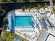 Aerial view of a large community pool and kiddie pool lined with lounge chairs and surrounded by palm trees at 3308 Oakwood S Blvd, Sarasota, FL 34237