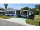 Charming manufactured home featuring a carport and a cozy sunroom enclosed with large awning style windows at 3308 Oakwood S Blvd, Sarasota, FL 34237