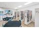 A community library room with a variety of book selections, tables, chairs, and a mounted television at 3308 Oakwood S Blvd, Sarasota, FL 34237