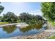 Scenic pond with a fountain and trees, reflecting a peaceful atmosphere at 3308 Oakwood S Blvd, Sarasota, FL 34237