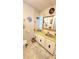 Bathroom featuring a toilet, sink, cabinets, mirror, and a light colored tile floor at 3308 Oakwood S Blvd, Sarasota, FL 34237