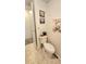 This bathroom features a toilet, wall decor, and light peach towel, with tile flooring and white walls at 3308 Oakwood S Blvd, Sarasota, FL 34237