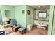 Bedroom with a rocking chair, side table and foot stool and light green paneled walls at 3308 Oakwood S Blvd, Sarasota, FL 34237