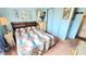 Bedroom featuring a bed with floral bedding, wood headboard, and dresser in blue room at 3308 Oakwood S Blvd, Sarasota, FL 34237