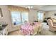 Bright dining area featuring a floral tablecloth, ceiling fan, and natural light from the window at 3308 Oakwood S Blvd, Sarasota, FL 34237
