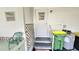 Exterior door with gray steps leading to the entrance, alongside a green trash bin and water heater at 3308 Oakwood S Blvd, Sarasota, FL 34237