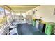 Outdoor patio featuring multiple seats, trash bins, water heater, and a screen enclosure at 3308 Oakwood S Blvd, Sarasota, FL 34237