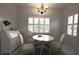 Cozy dining room featuring a white table, chairs, and a decorative chandelier, bathed in natural light at 3803 54Th W Dr # 201, Bradenton, FL 34210