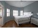Comfortable main bedroom features a large window with light-filtering shutters and hardwood floors at 3803 54Th W Dr # 201, Bradenton, FL 34210