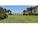 A manicured lawn leads to the building in this community featuring a tranquil pond and swaying palm trees at 4037 Crockers Lake Blvd # 14, Sarasota, FL 34238