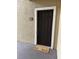 Brown front door with white trim and a 'HOME' welcome mat on a textured porch at 4037 Crockers Lake Blvd # 14, Sarasota, FL 34238