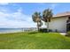 Lush backyard leads to the waterfront, complemented by mature palm trees at 4234 Gulf Of Mexico Dr # G2, Longboat Key, FL 34228