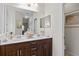 Bathroom featuring double sinks, dark wood cabinetry, and a large mirror at 4402 Natures Reach Ter, Parrish, FL 34219