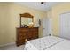 Bedroom with light-yellow walls, wooden dresser, and white trim at 4402 Natures Reach Ter, Parrish, FL 34219