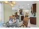 Bright breakfast nook with glass table, wicker chairs, and views into the kitchen and dining area at 4402 Natures Reach Ter, Parrish, FL 34219