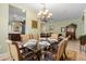 Dining area featuring a glass table with seating for six and an elegant chandelier at 4402 Natures Reach Ter, Parrish, FL 34219
