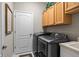 Laundry room boasts a washer and dryer set with wooden cabinetry at 4402 Natures Reach Ter, Parrish, FL 34219